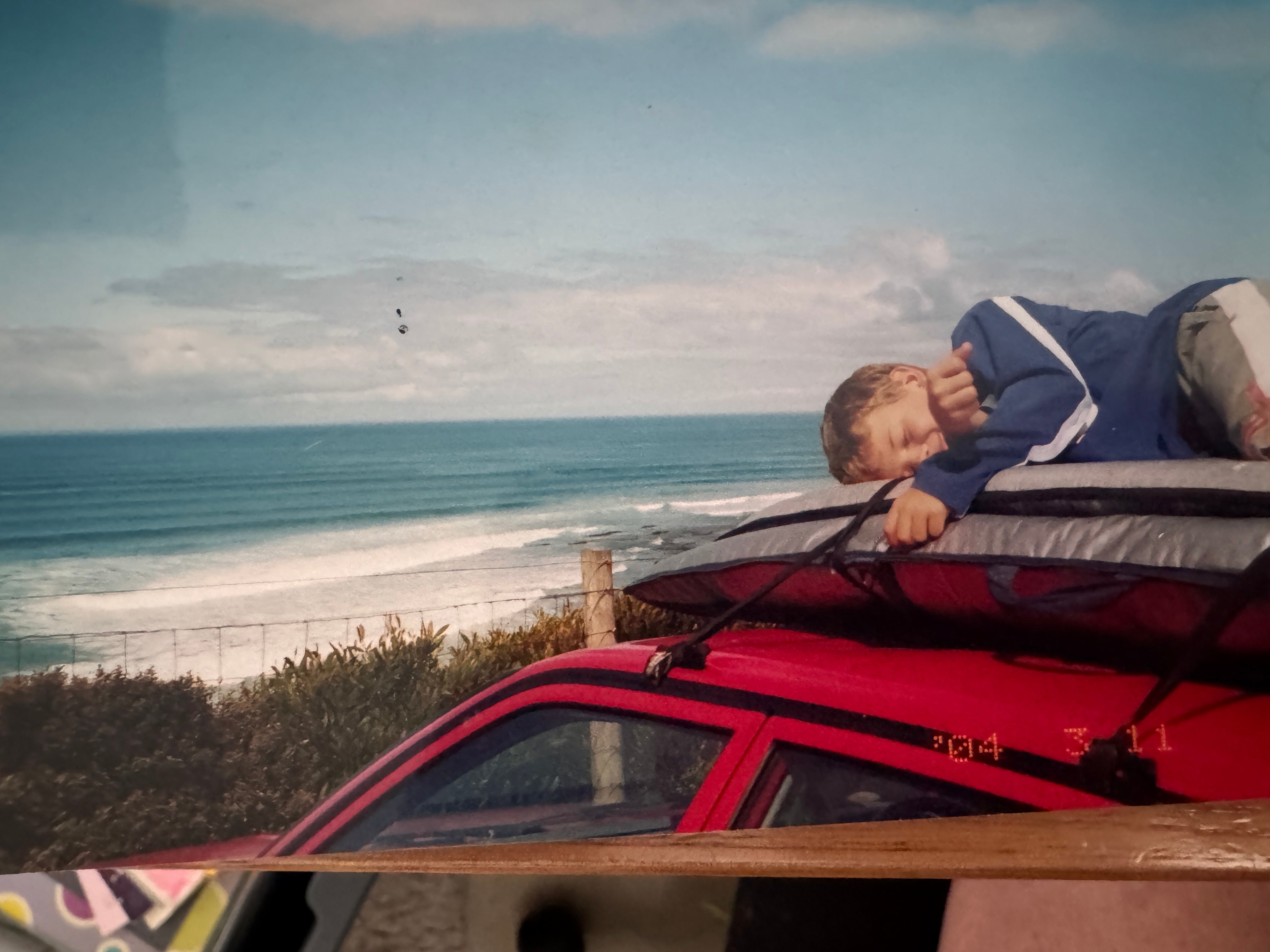 A young grom asleep on the boards on the car roof