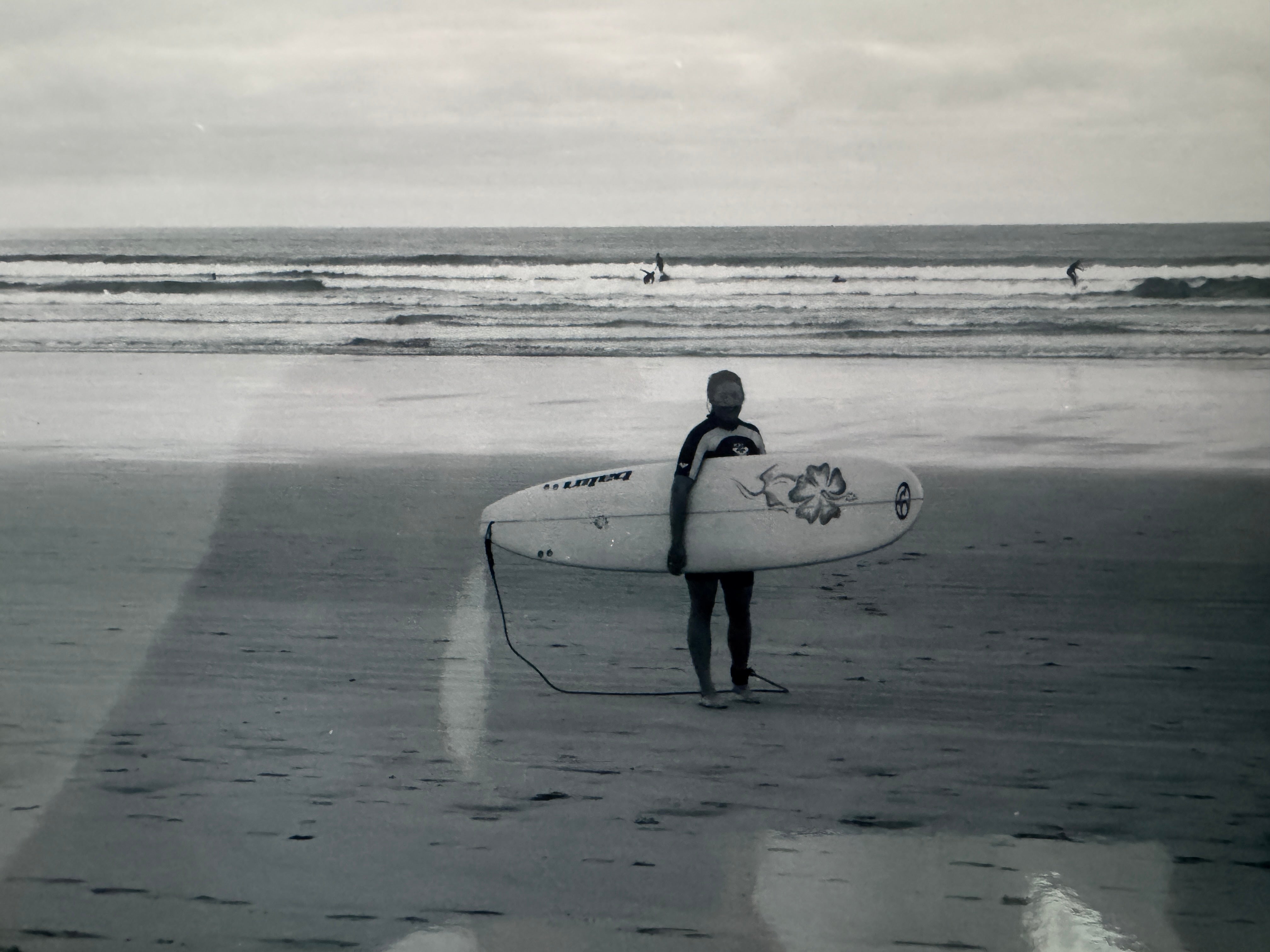 Walking up the sand after a surf
