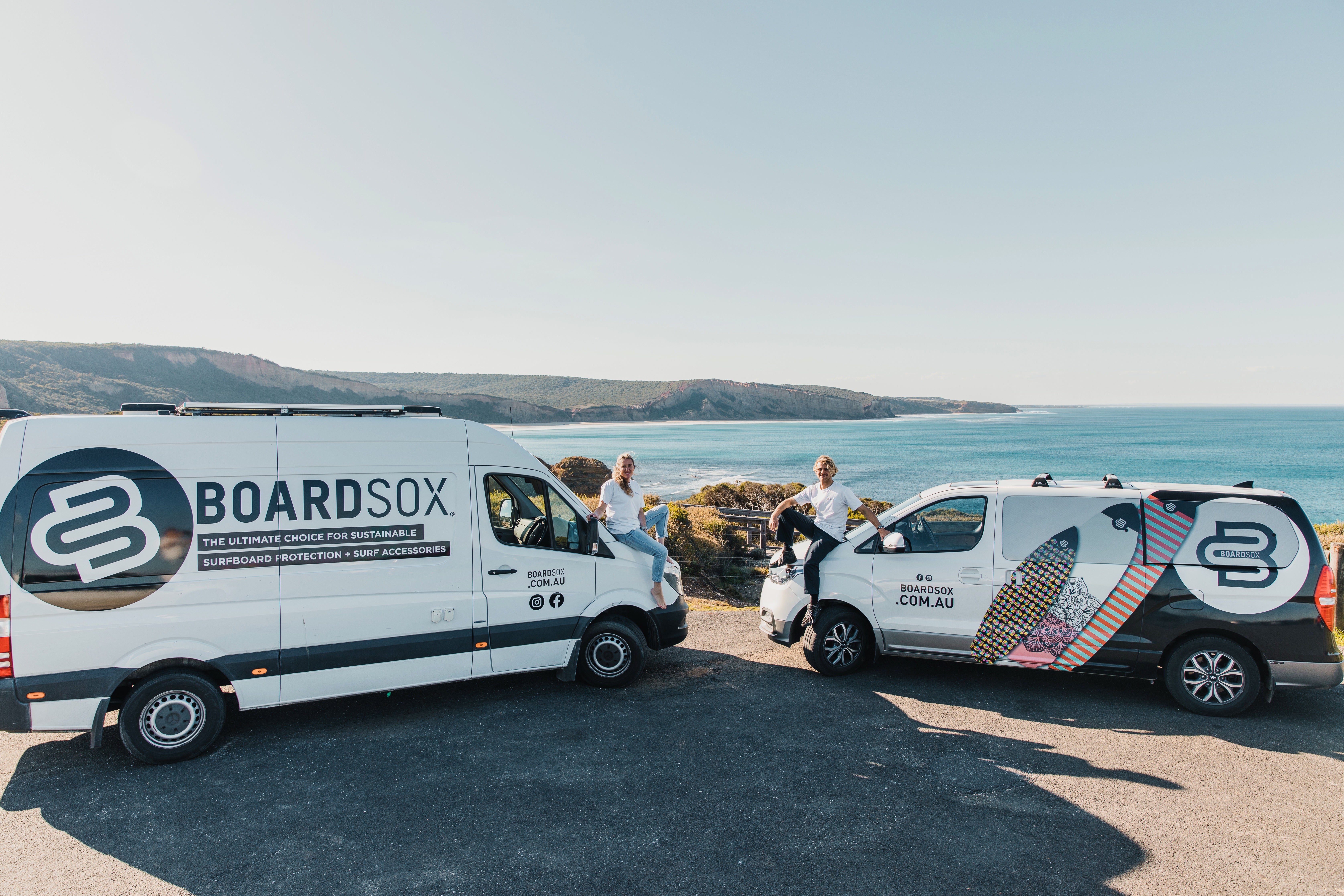 Dan and Sarah on their branded Boardsox vans overlooking the Great Ocean Road coast